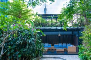 广州广州国际金融中心雅诗阁服务公寓 - 广交会免费穿梭巴士的庭院里设有蓝色的椅子和树木