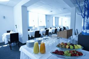 路德维希堡路德维希堡城市绿洲酒店的用餐室配有带水果的白色桌子