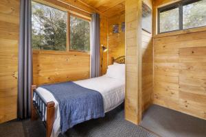 Mole Creek摩尔溪度假村小木屋的小木屋内的小卧室配有一张床