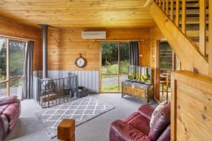 Mole Creek摩尔溪度假村小木屋的客厅设有木墙和木制天花板
