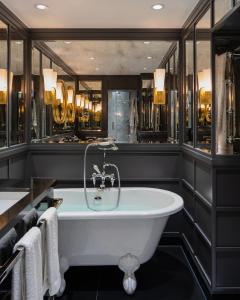 伦敦11 Cadogan Gardens, The Apartments and The Chelsea Townhouse by Iconic Luxury Hotels的带浴缸的浴室和黑色墙壁