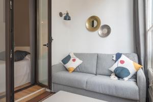巴塞罗那赫斯特林巴塞罗那格兰维亚酒店的客厅配有灰色的沙发和镜子