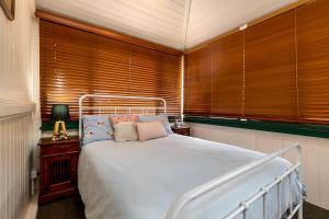 史丹霍普迪伦斯乡村民宿的一间卧室配有一张带木制百叶窗的床