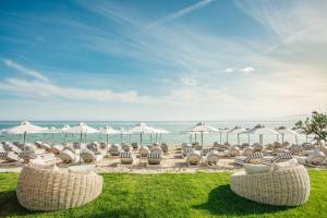 佩科霍里Blue Carpet Luxury Suites的海滩上的一组椅子和遮阳伞