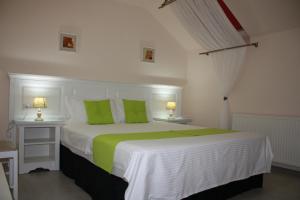 德瓦Silva House的卧室配有带绿色枕头的大型白色床