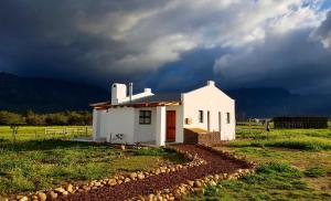 塔尔巴赫Duikersdrift Winelands Country Escape的暴风雨中的一个白色小房子