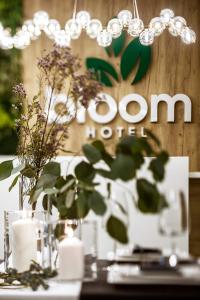 拉辛Bloom Hotel Airport Okęcie的一张带鲜花的桌子和一个读酒店时用的标志