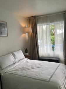 劳德代尔堡Hotel Motel Lauderdale Inn的卧室配有白色的床和窗户。