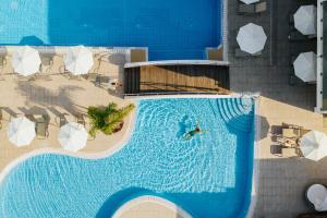 帕福斯Sofianna Resort & Spa的游泳池的顶部景色,里面的人