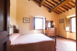 安吉亚里Appartamenti con cucina nelle colline toscane的一间卧室配有一张床、梳妆台和窗户。