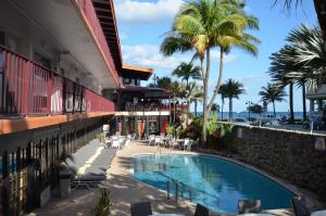 劳德代尔堡海洋度假村俱乐部酒店的棕榈树建筑旁边的游泳池