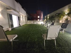 苏拉特桔子国际酒店的一间设有椅子的客房,绿地种植着植物