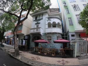 里约热内卢拉加托科帕卡巴纳旅馆的一座建筑前面设有红色伞的桌子