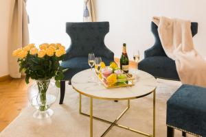 克拉根福Palais Gutenberg l´atelier的客厅配有带香槟和鲜花的桌子