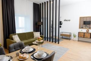 维也纳La Vienna Suites - Apartments Hauptbahnhof的客厅配有绿色沙发和桌子