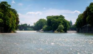 慕尼黑慕尼黑市中心假日酒店的享有河流、桥梁和树木的景色