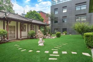 北京北京德胜门华宇假日酒店的一座花园,在一座建筑前面的草地上建有雕像