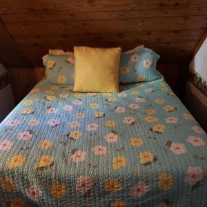 大熊湖Grey Squirrel Resort的一张带蓝色床罩的床,上面有鲜花