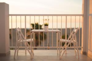 瓦伦西亚Sol Playa Suites的阳台上配有一张白色的桌子和两把椅子