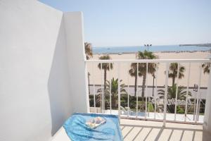 瓦伦西亚Sol Playa Suites的享有海滩和棕榈树景致的阳台