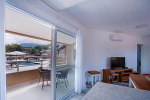 伊利亚贝拉Ilhabela Beach Residences的客房设有带桌子和电视的阳台。