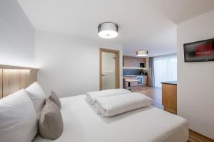 索尔登蒙塔纳罗公寓式酒店的一间带白色床的卧室和一间客厅