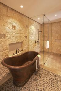 瓦哈卡市Hotel Casa Santo Origen的带淋浴的浴室设有大型木制浴缸