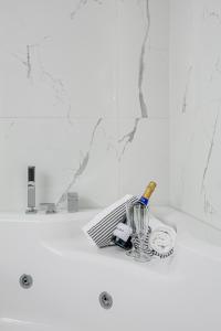 卡尔斯塔德Best Western Hotel Savoy的一个带水槽的浴室台面和一瓶香槟