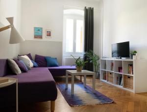 的里雅斯特Casa Strehler的客厅配有紫色沙发和电视