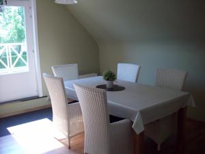 托尔豪特B&B Wijnendalvallei的一间带桌子和白色椅子的用餐室