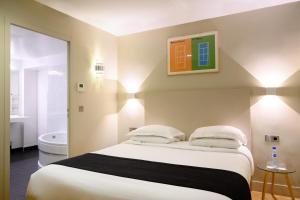 巴黎赫尔奇尔伊托勒套房酒店的一间带大床的卧室和一间浴室