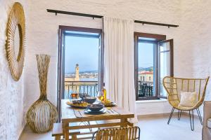 罗希姆诺Vista Del Porto Luxury Suites的一间带桌子的用餐室和一个阳台