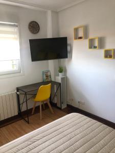 莫格罗El Pinar de Mogro的一间卧室配有书桌和黄色椅子