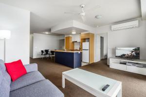 布里斯班古德温码头公寓式酒店的带沙发和桌子的客厅以及厨房。