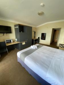 塔里塔里汽车旅馆的一间酒店客房,配有一张白色大床