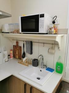 珀斯BHA unit 5的厨房柜台设有水槽和微波炉