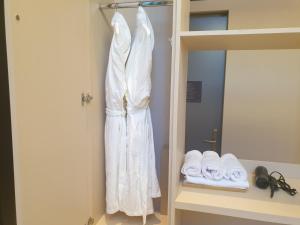 始兴市Hotel Libre的挂在床边墙上的白色长袍