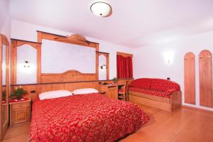 卡纳泽伊Hotel il Caminetto Sport的卧室设有红色大床和窗户。