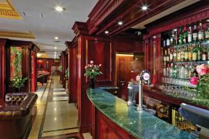 伦敦Gem Fitzrovia Hotel的一间酒吧,设有红色的墙壁和绿色的柜台