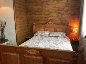 索尔兹伯里惠特谢夫住宿加早餐旅馆的卧室配有一张床铺,位于带木墙的房间内
