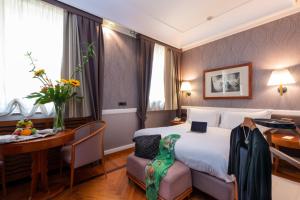 锡拉库扎奥提伽大酒店的配有一张床、一张桌子和一张桌子的酒店客房