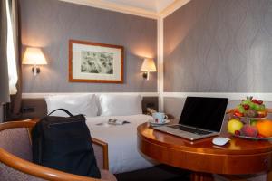 锡拉库扎奥提伽大酒店的酒店的客房配有一张带笔记本电脑的书桌