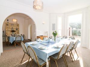托基Babbacombe Hall的一间配备有蓝色桌子和椅子的用餐室