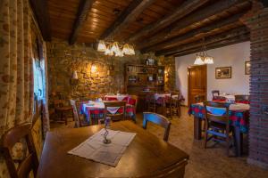阿莫雷维耶塔-埃查诺CASA RURAL ETXANO的一间带桌椅和石墙的餐厅