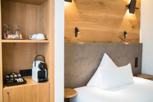 埃兴Olymp Munich的一间卧室配有一张带木制床头板的床