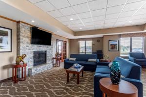 卡本代尔Comfort Inn & Suites Carbondale University Area的客厅设有蓝色的沙发和壁炉