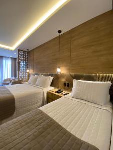 新彼得罗波利斯Pousada Brombatti的酒店客房配有两张床和一张书桌