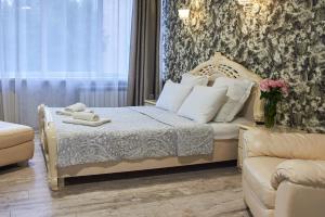 波尔塔瓦Hotel Royal (Отель Роял)的一间卧室配有一张床和一张沙发