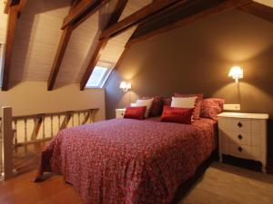 维耶拉Hotel Ostau d'Òc的一间卧室配有一张带红色床单的床和一扇窗户。
