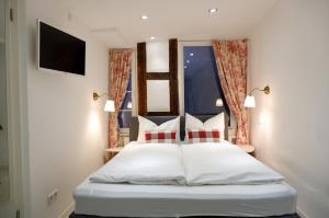 蒂宾根泽特瑞银穆海泽德爱特斯坦德公寓的卧室配有白色床和红色及白色枕头